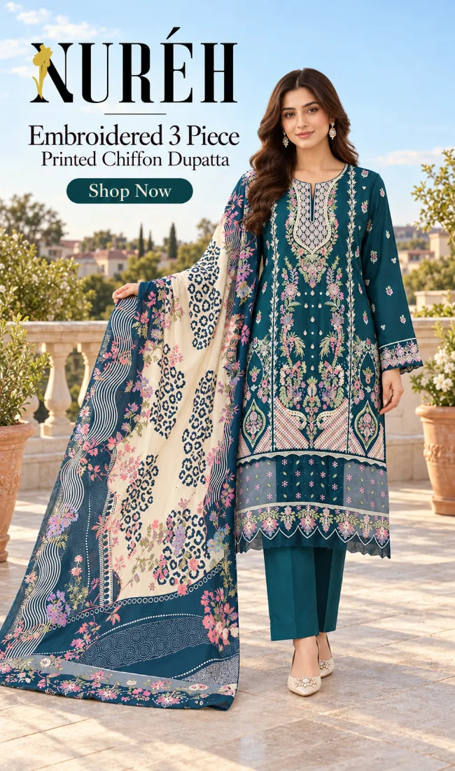 A woman models a three-piece embroidered chiffon suit by NURÉH, featuring a teal kurta with intricate floral embroidery, matching teal pants, and a large printed dupatta with cream, teal, and floral patterns, set against an outdoor terrace background.