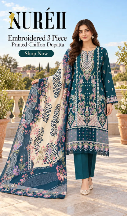 A woman models a three-piece embroidered chiffon suit by NURÉH, featuring a teal kurta with intricate floral embroidery, matching teal pants, and a large printed dupatta with cream, teal, and floral patterns, set against an outdoor terrace background.